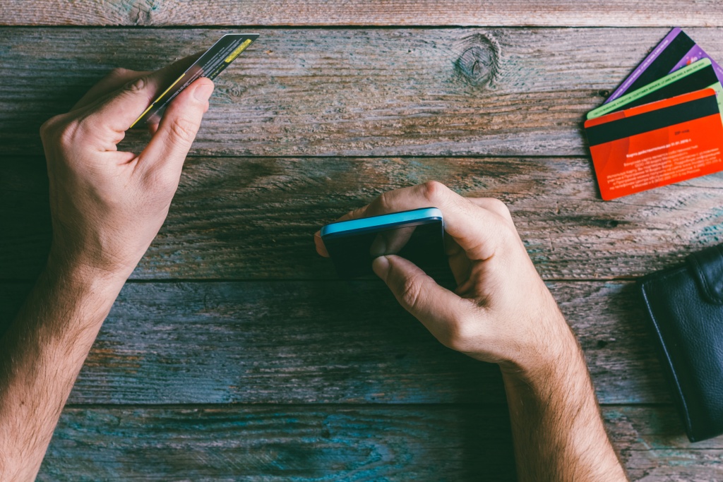man-hands-holding-credit-card-using-mobile-phone.jpg руки